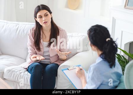 Woman Sitting on Couch Talking to Therapist Stock Photo