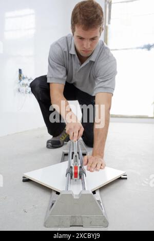 Bricklayer cutting tile. Manual tile cutter. Construction Industry. Stock Photo