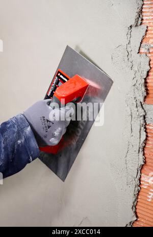 Rendering a brick wall using trowel, new homes under construction, construction site Stock Photo