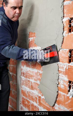 Rendering a brick wall using trowel, new homes under construction, construction site Stock Photo