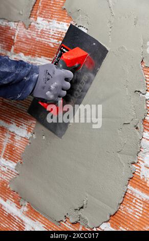 Rendering a brick wall using trowel, new homes under construction, construction site Stock Photo