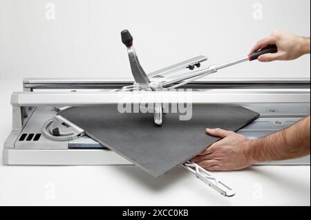 Bricklayer cutting tile. Manual tile cutter. Construction Industry. Stock Photo