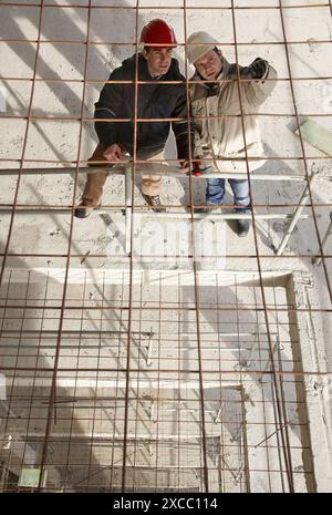 Architect and construction worker, personal protective equipment, housing construction, concrete skeleton Stock Photo