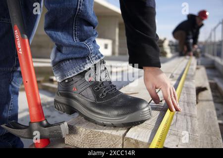 Construction workers measuring, personal protective equipment, housing construction Stock Photo