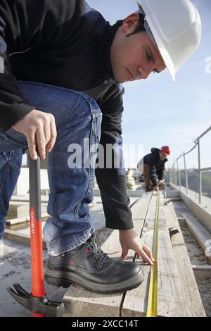 Construction workers measuring, personal protective equipment, housing construction Stock Photo