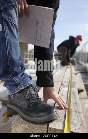 Construction workers measuring, personal protective equipment, housing construction Stock Photo