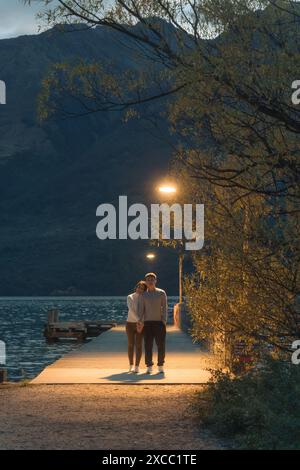 Asian couple standing and enjoying on wooden pier under the light at Glenorchy famous place, New Zealand Stock Photo