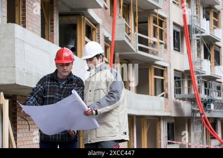 Workers with blueprints. Building construction. Stock Photo