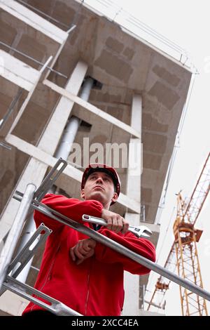 Worker holding adjustable spanner in a construction site Stock Photo