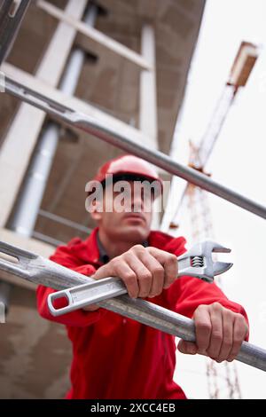 Worker holding adjustable spanner in a construction site Stock Photo