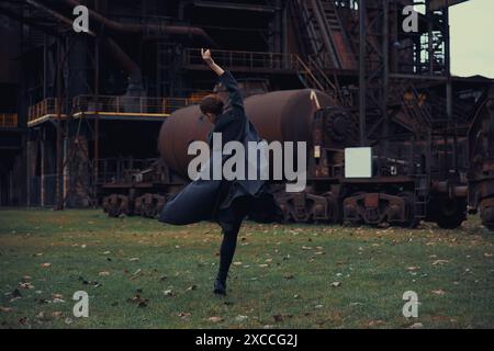 Ballerina against the backdrop of a huge abandoned factory Stock Photo