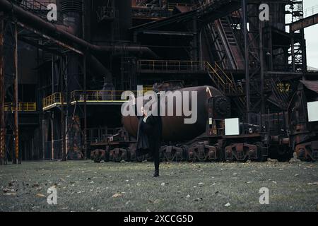 Ballerina against the backdrop of a huge abandoned factory Stock Photo