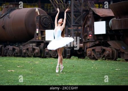 Ballerina against the backdrop of a huge abandoned factory Stock Photo