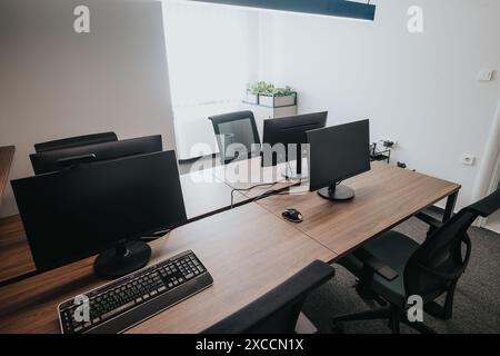 Modern office space with multiple monitors on a shared desk enhancing productivity Stock Photo