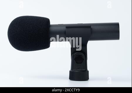Black cylinder microphone in wind protection with holder isolated side view Stock Photo