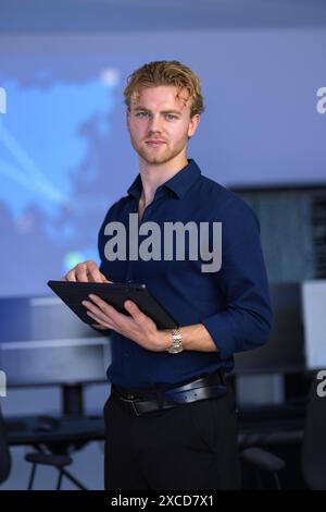 Male Cybersecurity Analyst in large Cyber Security Operation Center SOC handling Threats Stock Photo