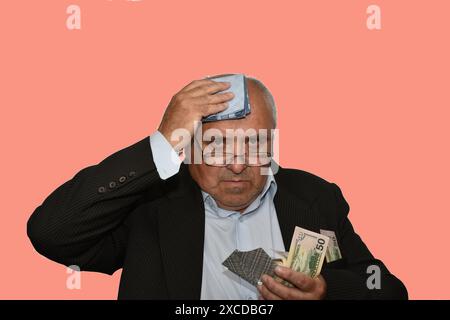 The picture shows a man who looks frightened. In one hand he holds money, and in the other a handkerchief with which he wipes his forehead. Stock Photo