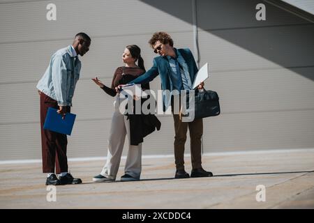 Multiracial business team brainstorming outdoors, analyzing statistics and strategizing for growth Stock Photo