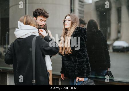 A group of young business colleagues conversing outdoors, surrounded by a gentle snowfall, capturing a blend of professionalism and winter atmosphere. Stock Photo