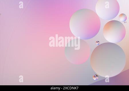 Circles in varying sizes on a pink and purple gradient background, creating an abstract, dreamy, and colorful pattern Stock Photo