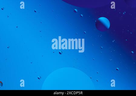 Serene abstract image with various sized blue and purple bubbles on dark blue background, creating calm visual effect Stock Photo