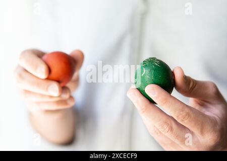 close up of hands holding crashed broken easter eggs Stock Photo