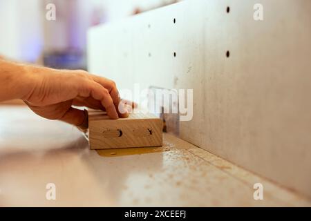 Woodworker using edge jointer in assembly studio for precision cutting of plank, making wooden objects, close up shot. Focus on wood shaper used by carpenter for smoothing out panels Stock Photo