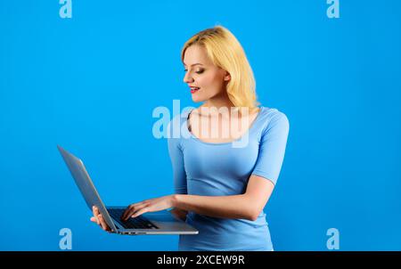 Smiling student freelancer woman using laptop for remote work, e-learning at university college, e-banking, online shopping, webinars. Beautiful girl Stock Photo