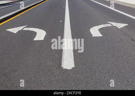 Directional arrows pointing left and right painted on a highway. Stock Photo