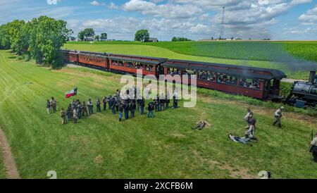 Ronks, Pennsylvania, USA, June 8, 2024 - Aerial View Of A Civil War Reenactment With Actors In Period Uniforms On A Grassy Field, Next To A Vintage Train, Depicting A Battle Scene With Participants And Spectators Under A Blue Sky. Stock Photo