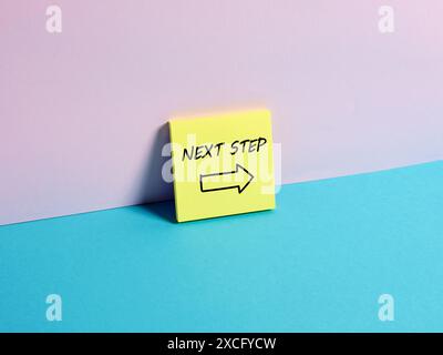 The message Next Step on a sticky note paper. Next level or step in business or education concept. Stock Photo
