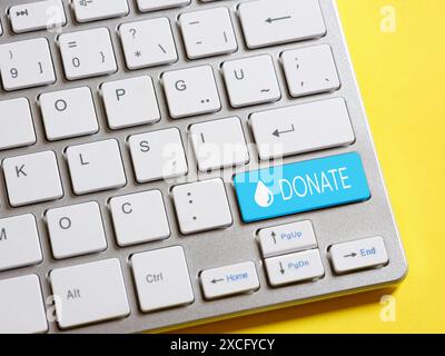 Making an online donation. Charity and relief work. To donate money. Computer keyboard with Donate button. Stock Photo