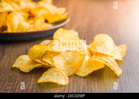 Crispy Potato Chips on a wooden table. Stock Photo