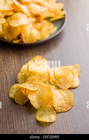 Crispy Potato Chips on a wooden table. Stock Photo