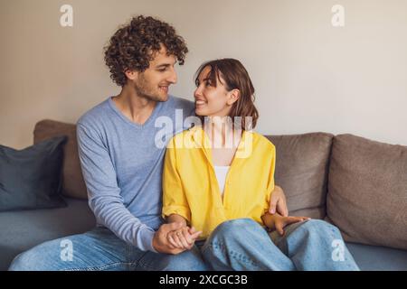 Portrait of young happy couple who is holding hands and smiling. Stock Photo