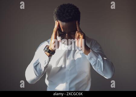 Portrait of young businessman who is tired and having headache. Stock Photo