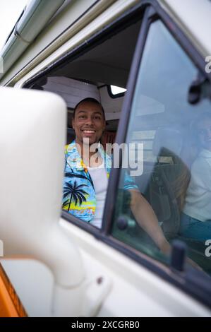 Cheerful travel couple riding van in daylight Stock Photo
