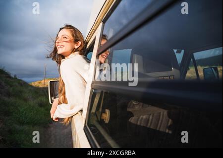 Happy young woman standing near door in driver seat Stock Photo