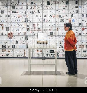 London, UK. 17th June, 2024. Staff with 'The Encyclopedia of Invisibility', 2024-2018 (leather, guilding archival paper) and 'Six Thousand Years, 2018, (2078 room filling panels), which makes use of the huge spaces at the Hayward. ‘Tavares Strachan: There Is Light Somewhere' will be on show at the Hayward Gallery 18 Jun -? 1 Sep and shows a cross section of the artist's work throughout his career. Credit: Imageplotter/Alamy Live News Stock Photo