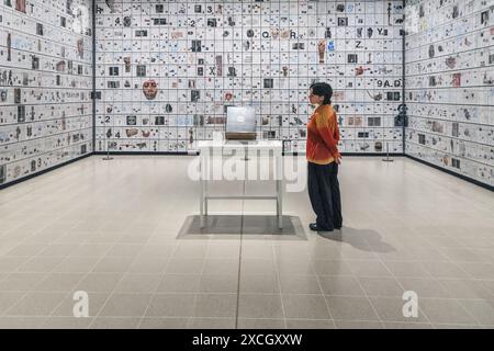 London, UK. 17th June, 2024. Staff with 'The Encyclopedia of Invisibility', 2024-2018 (leather, guilding archival paper) and 'Six Thousand Years, 2018, (2078 room filling panels), which makes use of the huge spaces at the Hayward. ‘Tavares Strachan: There Is Light Somewhere' will be on show at the Hayward Gallery 18 Jun -? 1 Sep and shows a cross section of the artist's work throughout his career. Credit: Imageplotter/Alamy Live News Stock Photo