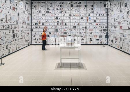 London, UK. 17th June, 2024. Staff with 'The Encyclopedia of Invisibility', 2024-2018 (leather, guilding archival paper) and 'Six Thousand Years, 2018, (2078 room filling panels), which makes use of the huge spaces at the Hayward. ‘Tavares Strachan: There Is Light Somewhere' will be on show at the Hayward Gallery 18 Jun -? 1 Sep and shows a cross section of the artist's work throughout his career. Credit: Imageplotter/Alamy Live News Stock Photo