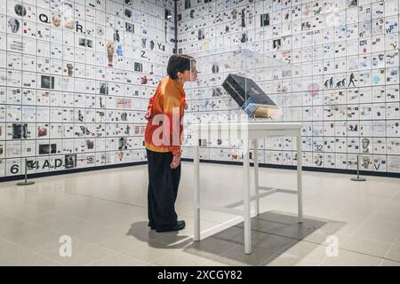 London, UK. 17th June, 2024. Staff with 'The Encyclopedia of Invisibility', 2024-2018 (leather, guilding archival paper) and 'Six Thousand Years, 2018, (2078 room filling panels), which makes use of the huge spaces at the Hayward. ‘Tavares Strachan: There Is Light Somewhere' will be on show at the Hayward Gallery 18 Jun -? 1 Sep and shows a cross section of the artist's work throughout his career. Credit: Imageplotter/Alamy Live News Stock Photo