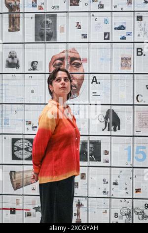 London, UK. 17th June, 2024. Staff with 'The Encyclopedia of Invisibility', 2024-2018 (leather, guilding archival paper) and 'Six Thousand Years, 2018, (2078 room filling panels), which makes use of the huge spaces at the Hayward. ‘Tavares Strachan: There Is Light Somewhere' will be on show at the Hayward Gallery 18 Jun -? 1 Sep and shows a cross section of the artist's work throughout his career. Credit: Imageplotter/Alamy Live News Stock Photo