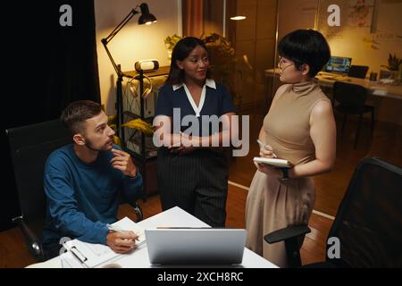 Multi-ethnic business team having meeting at night in office Stock Photo
