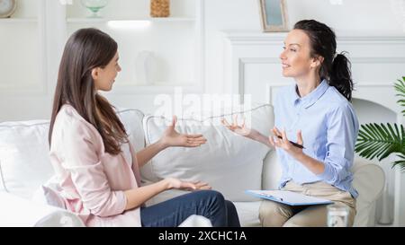 Two Women Engaging in Therapy Session on Cozy Sofa Stock Photo