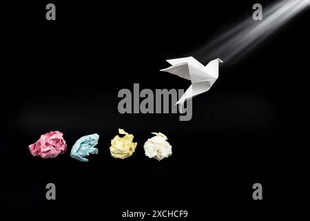 Colored crumpled paper balls and a origami white dove on black Stock Photo