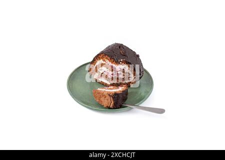 Chocolate roll with cheese and forest fruits filling on a ceramic plate, isolated on  white Stock Photo