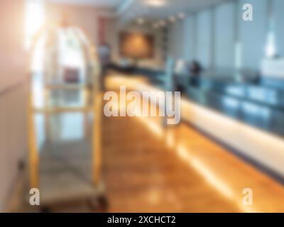 Abstract blur luxury hotel lobby luxury interior for Background, decoration with empty gold baggage trolley and reception counter. Blurred scene front Stock Photo