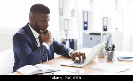 Young african american entrepreneur studying competitors online Stock Photo