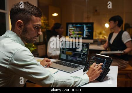 Developer checking programming code on tablet and laptop Stock Photo